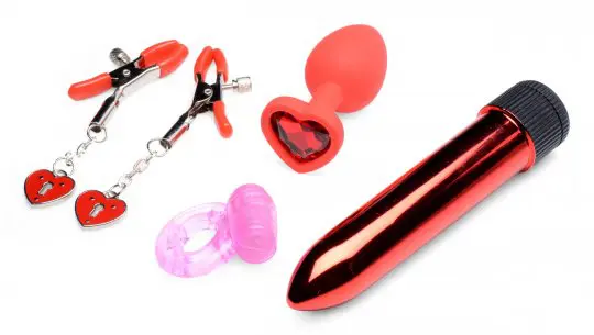 A variety of sex toys are laying out on the table.