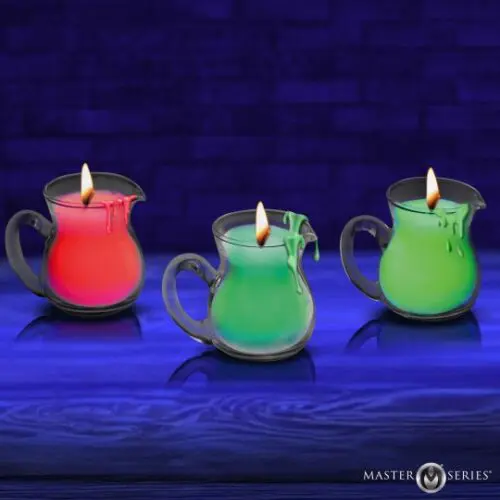 Three colorful candles in glass holders glowing against a dark blue background.