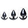 Three black rubber butt plugs of varying sizes.