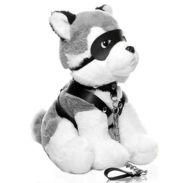 A gray and white plush dog with a leather harness and chain.