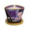 A lit candle with a purple and gold design.