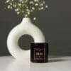 Black candle in a tin container.