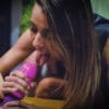 A woman is licking her pink dildo