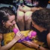 Two women are playing with a purple toy.