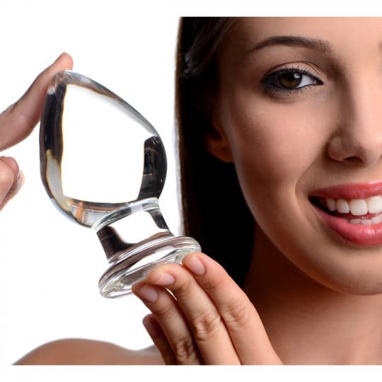 Clear glass butt plug held by a woman.