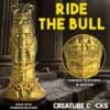 A statue of a gold colored object with the words " creature cocks " underneath it.