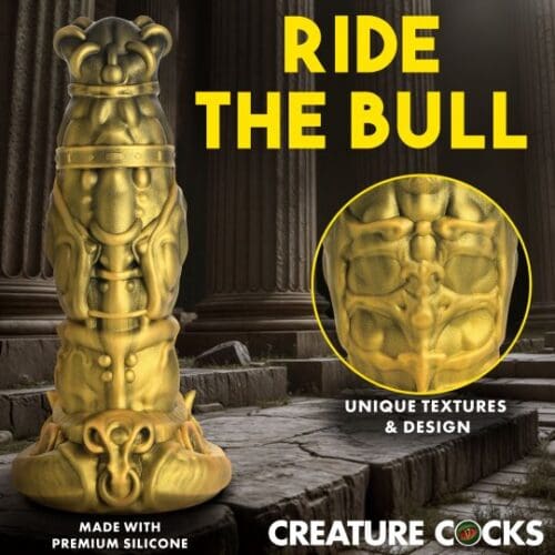 A statue of a gold colored object with the words " creature cocks " underneath it.