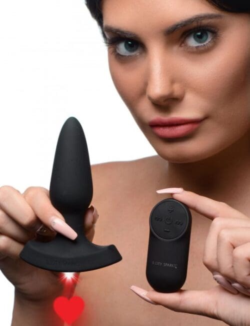 A woman is holding a black toy and looking at the camera.