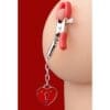 A red heart shaped key chain hanging from the side of a woman 's butt.