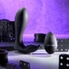 A black sex toy and some other toys on a table.