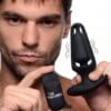 A man holding up an electronic device and another device.