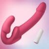 A pink and white condom is next to a pink dildo.