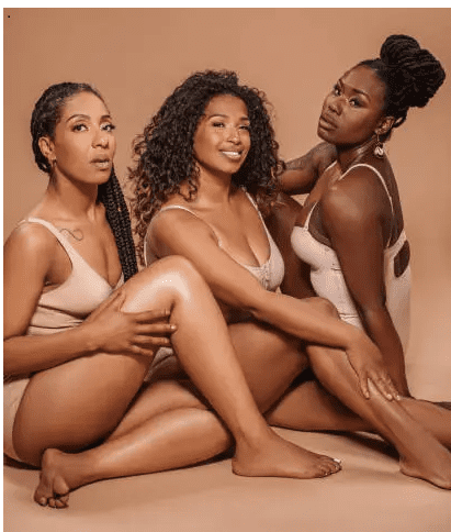 gettyimages-1598086122-612x612-1 Three women posing in neutral-toned outfits.